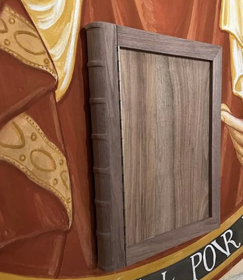 Coffret en forme de livre en noyer, intégré à une fresque d'édifice religieux